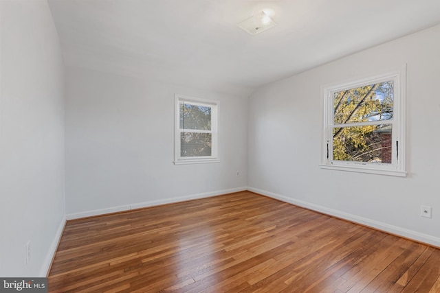 empty room featuring baseboards and hardwood / wood-style flooring