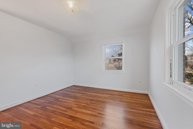 unfurnished room featuring baseboards and wood-type flooring