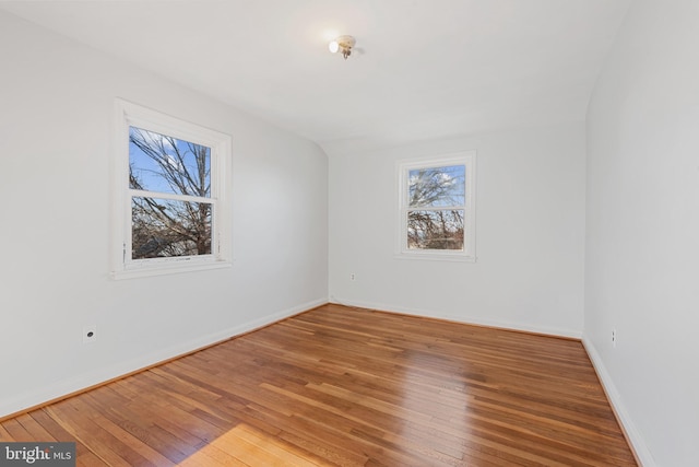 spare room featuring baseboards and hardwood / wood-style flooring