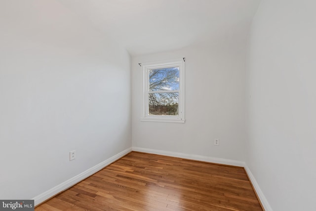 empty room with hardwood / wood-style floors and baseboards