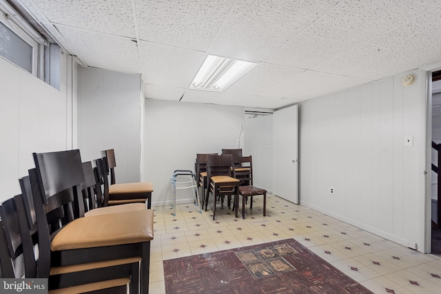 dining space with tile patterned floors and a drop ceiling