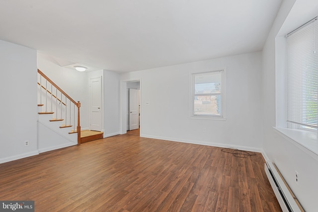 unfurnished room with stairway, baseboards, baseboard heating, and wood finished floors