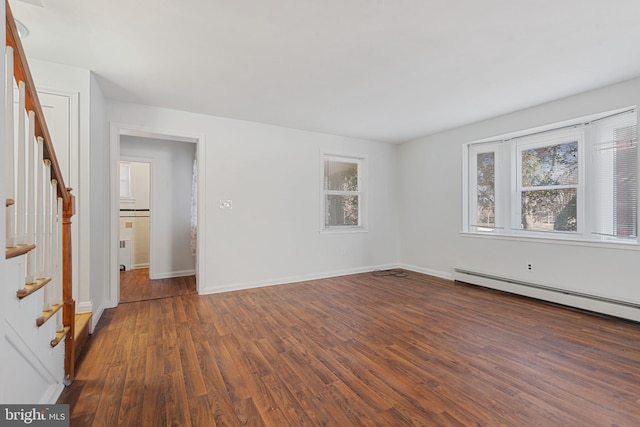 unfurnished room with wood finished floors, stairs, baseboards, and a baseboard radiator