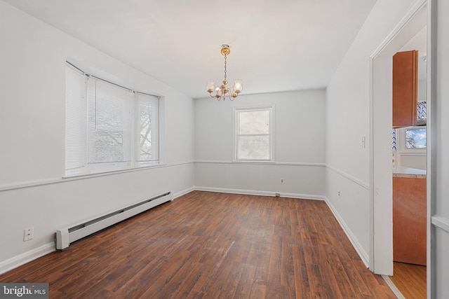 spare room featuring baseboards, baseboard heating, an inviting chandelier, and hardwood / wood-style flooring