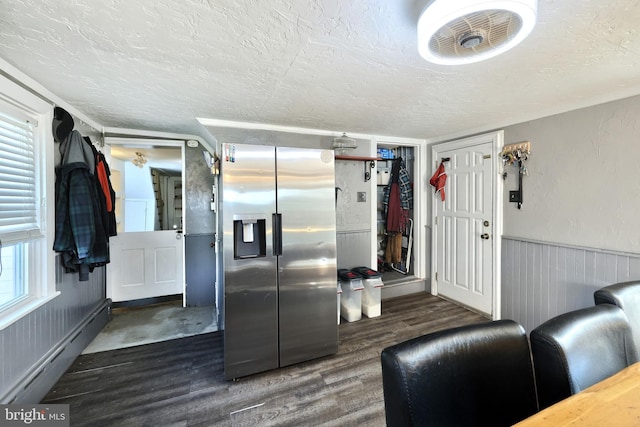 kitchen featuring visible vents, a baseboard heating unit, a textured ceiling, wood finished floors, and stainless steel fridge