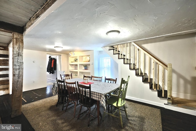 dining space with baseboards, wood finished floors, and stairs