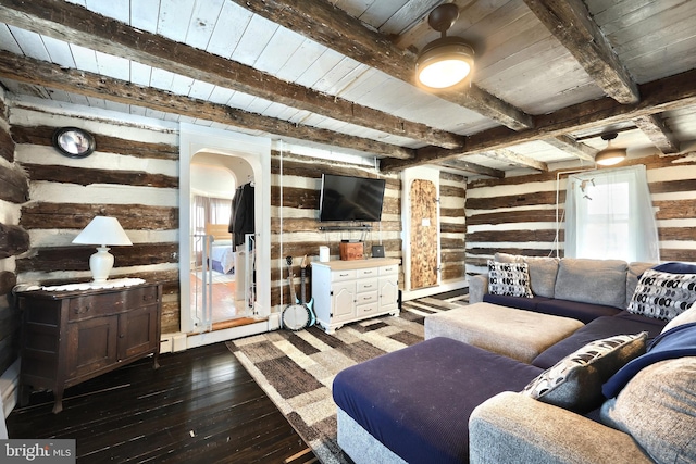 living room featuring beam ceiling, arched walkways, wood walls, wood ceiling, and dark wood-style flooring