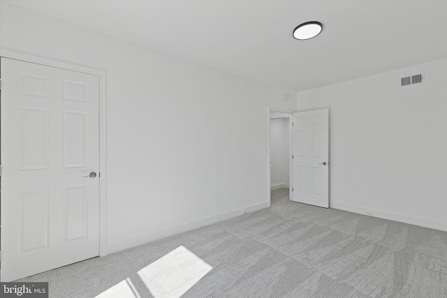 unfurnished room featuring carpet flooring, visible vents, and baseboards