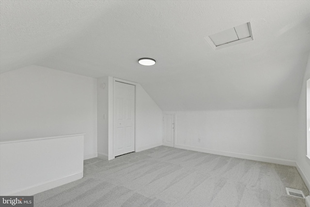 bonus room featuring visible vents, baseboards, vaulted ceiling, carpet floors, and a textured ceiling