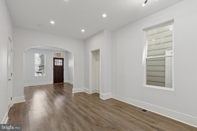 entrance foyer with visible vents, wood finished floors, recessed lighting, arched walkways, and baseboards