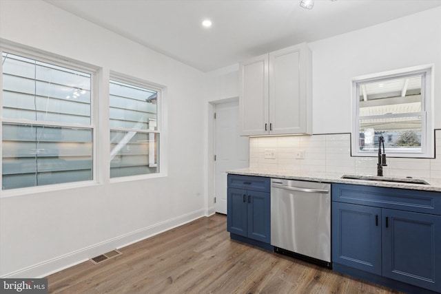 kitchen featuring a sink, blue cabinetry, tasteful backsplash, and dishwasher