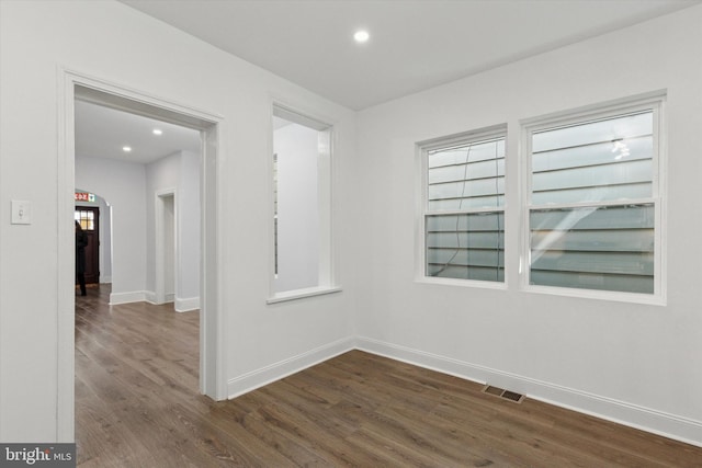 unfurnished room with visible vents, recessed lighting, dark wood-type flooring, and baseboards