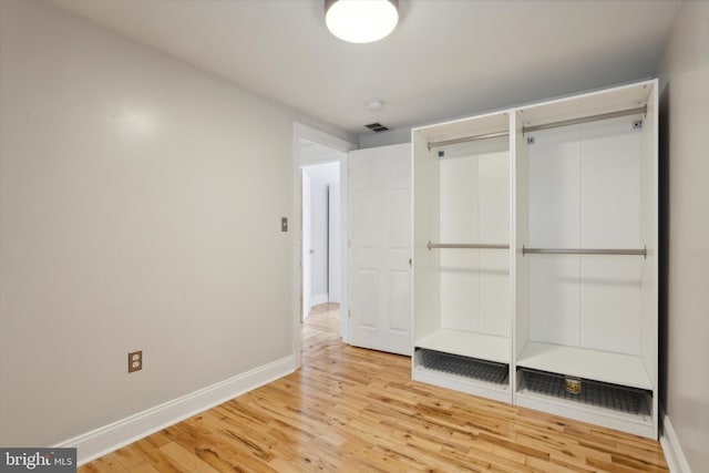 unfurnished bedroom with visible vents, baseboards, and wood finished floors