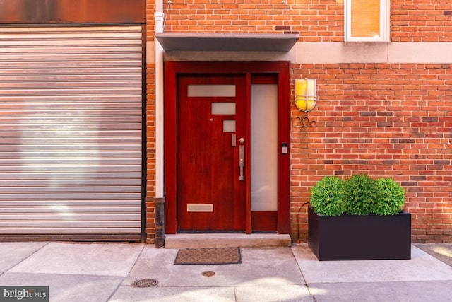 view of exterior entry featuring brick siding