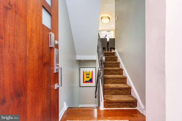 stairway featuring wood finished floors and baseboards