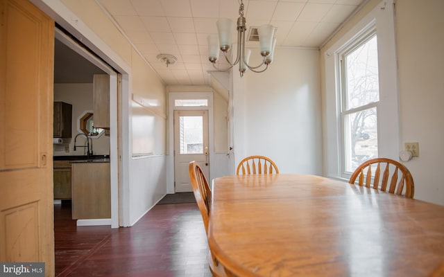 dining space with a notable chandelier, dark wood-style flooring, and a wealth of natural light