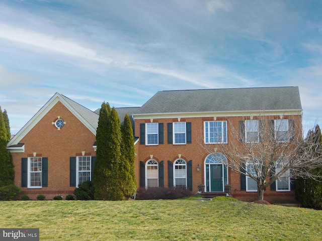 view of front of property featuring brick siding and a front yard