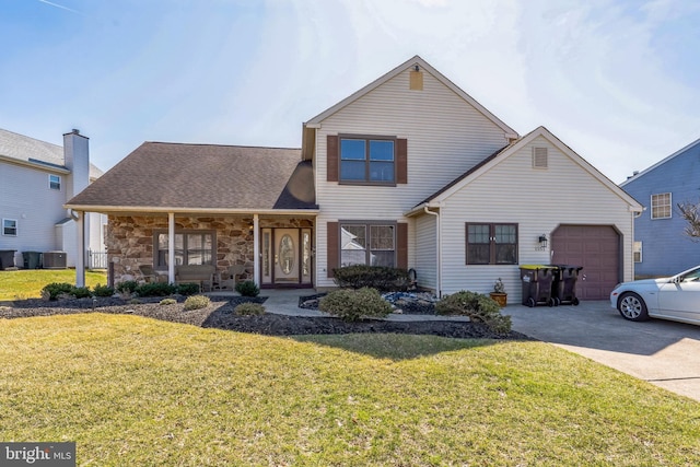 traditional-style home with a porch, concrete driveway, a front lawn, and an attached garage