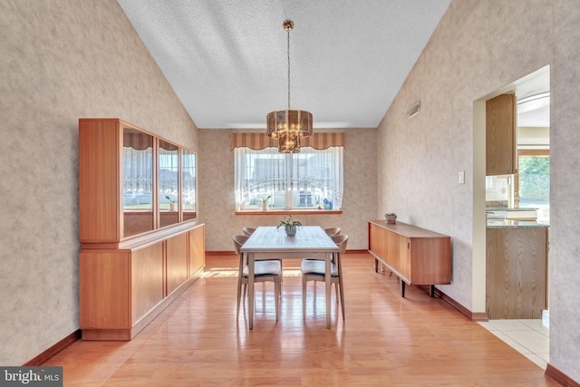 dining room featuring light wood-type flooring, an inviting chandelier, and a healthy amount of sunlight