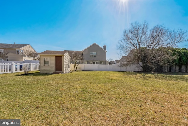 view of yard with an outbuilding, a fenced backyard, and a storage shed