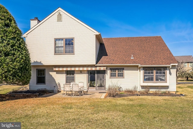 back of property with a patio, a lawn, a chimney, and a shingled roof