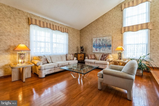 living area with high vaulted ceiling and hardwood / wood-style floors