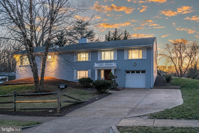 view of front facade with concrete driveway, a chimney, a garage, and fence