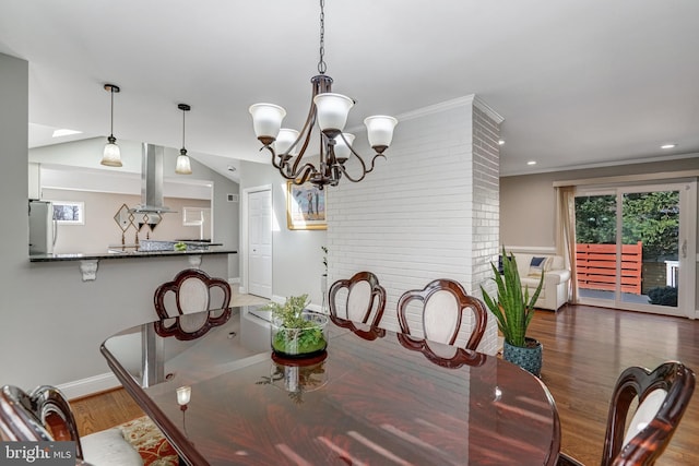 dining room with crown molding, baseboards, vaulted ceiling, wood finished floors, and a notable chandelier