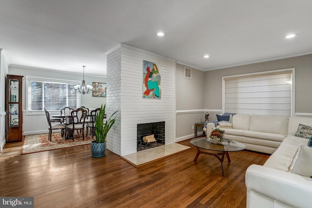 living room with crown molding, recessed lighting, wood finished floors, and visible vents