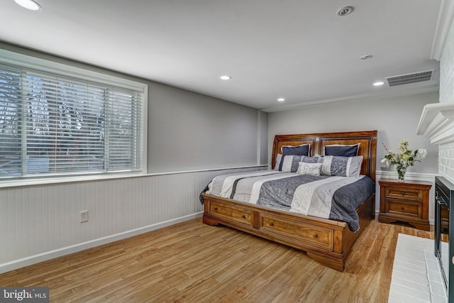 bedroom with visible vents, recessed lighting, a wainscoted wall, and wood finished floors