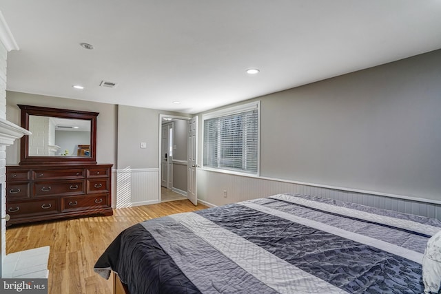 bedroom featuring recessed lighting, visible vents, light wood-type flooring, and wainscoting