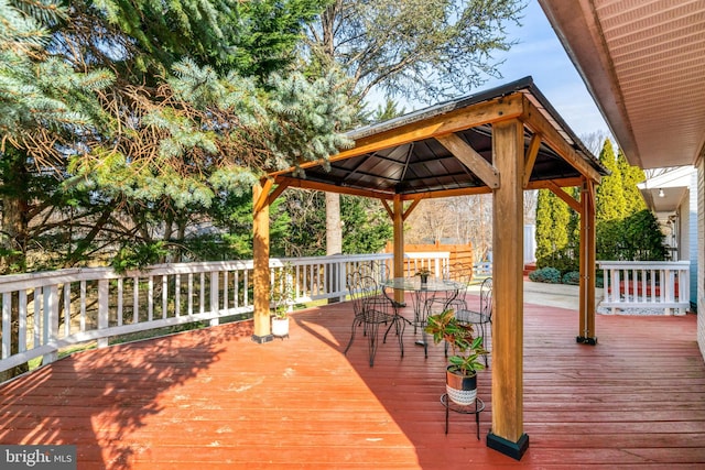 deck with a gazebo and outdoor dining area