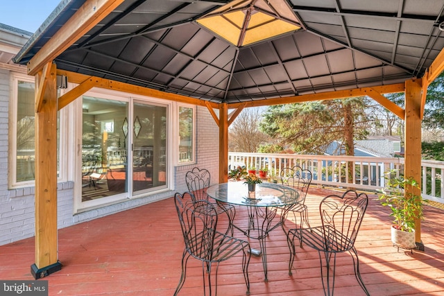 wooden deck featuring outdoor dining space and a gazebo