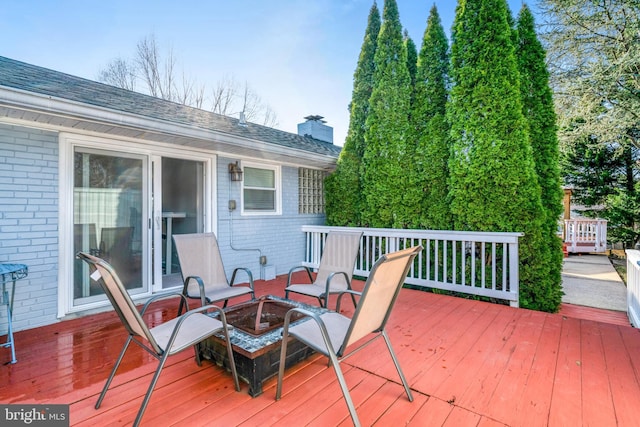 wooden deck featuring an outdoor fire pit