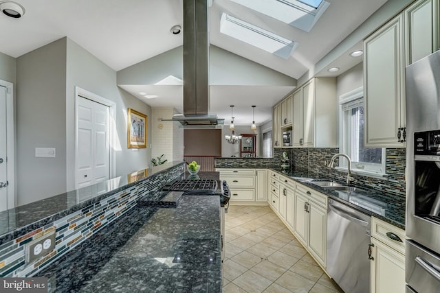 kitchen with cream cabinetry, island exhaust hood, stainless steel appliances, and a sink