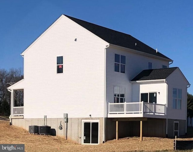 rear view of property with central AC unit and a wooden deck