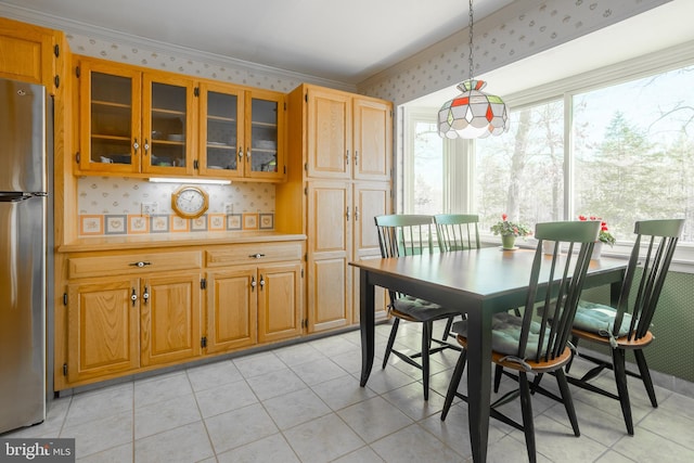 dining room featuring wallpapered walls, crown molding, and light tile patterned flooring