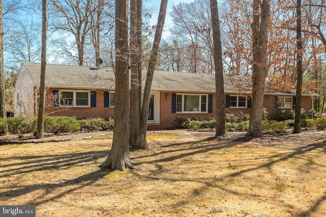 ranch-style house featuring a front yard and brick siding