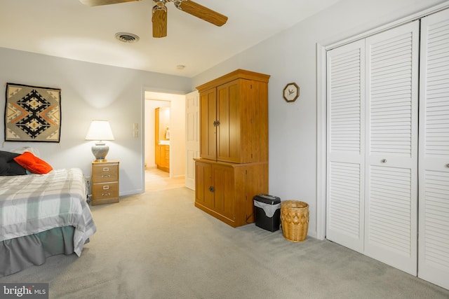 bedroom with a closet, visible vents, light colored carpet, and ceiling fan