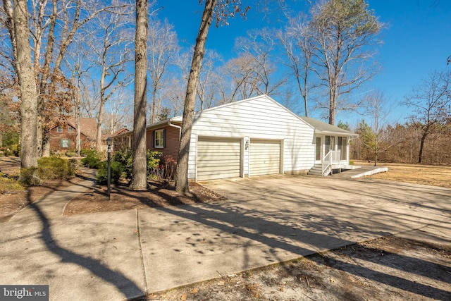 view of side of home featuring a garage and driveway