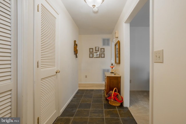 hallway with visible vents and baseboards