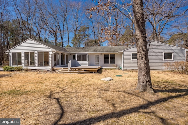 rear view of house with crawl space, a deck, a yard, and a sunroom