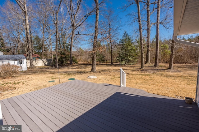 wooden terrace with an outdoor structure and fence