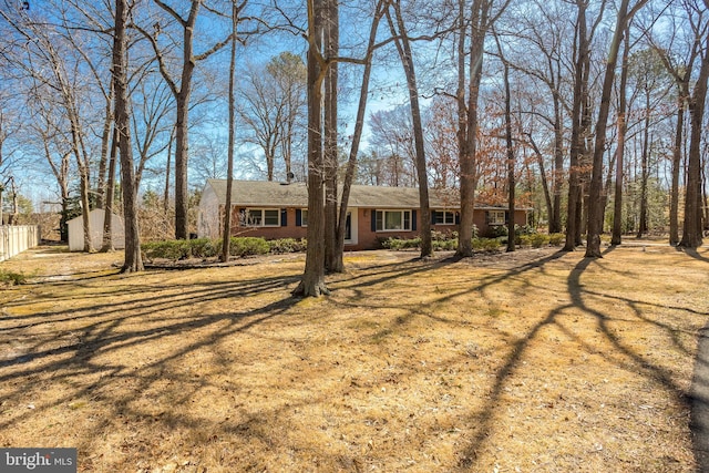 view of front of property featuring brick siding, a front yard, and fence