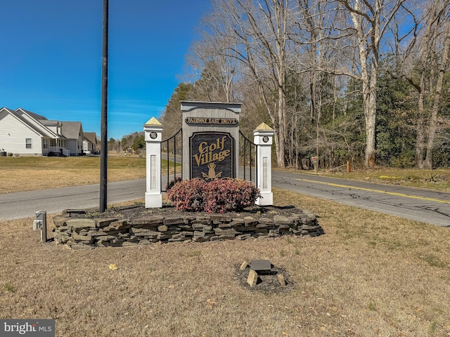 community / neighborhood sign featuring a lawn