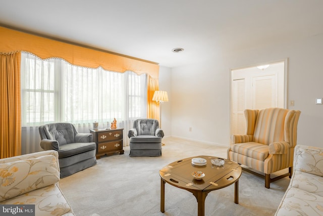 living area featuring visible vents, baseboards, and carpet