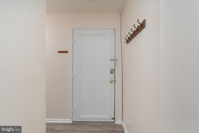 doorway with baseboards and light wood-style floors