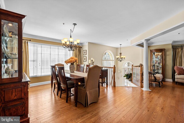 dining room featuring light wood-type flooring, a notable chandelier, and crown molding