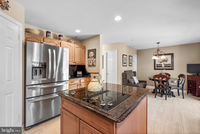 kitchen with dark stone countertops, recessed lighting, stainless steel refrigerator with ice dispenser, decorative light fixtures, and black electric cooktop