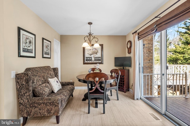 dining room with baseboards, visible vents, and a chandelier